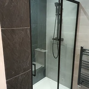 a walk in shower sitting next to a toilet