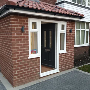 a small brick house with a black door