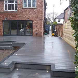 a backyard with a wooden deck and benches